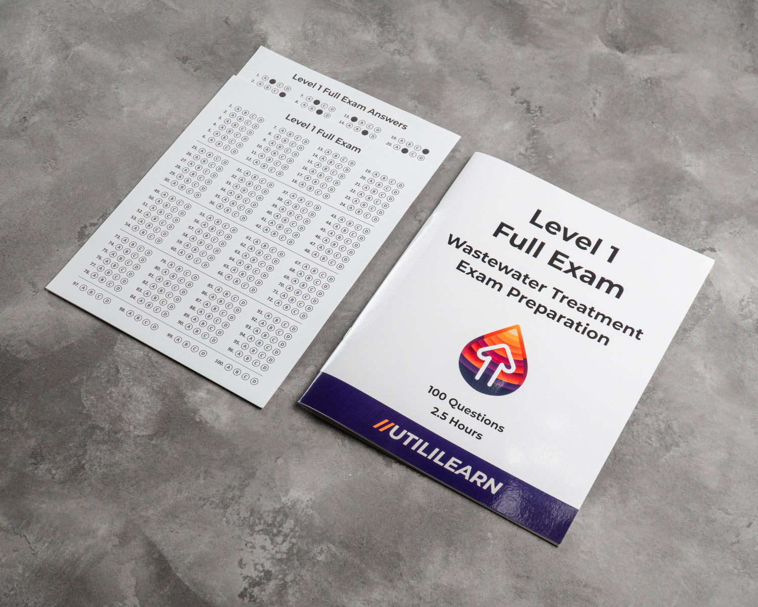 Exam preparation book and answer sheet on a concrete surface